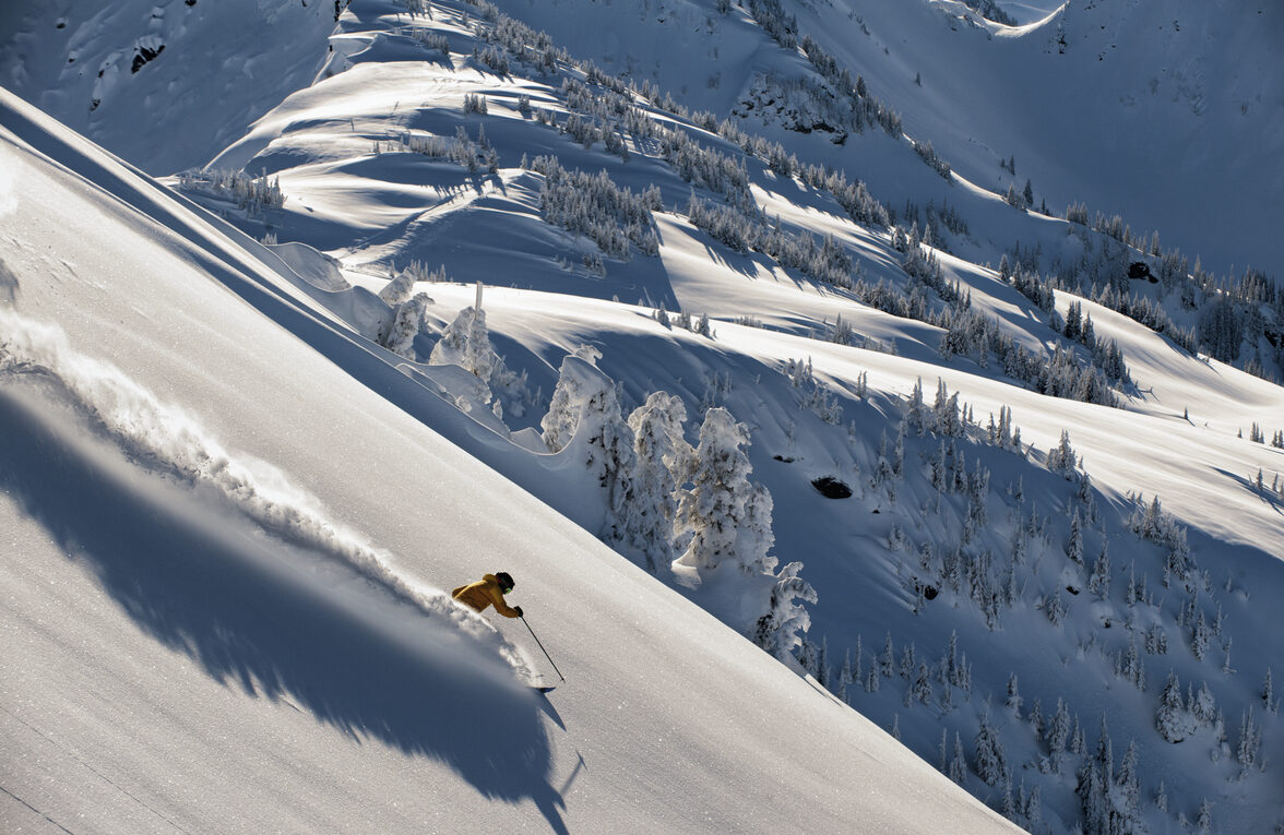 Lone skiier Skiing down a steep sloped mountain face