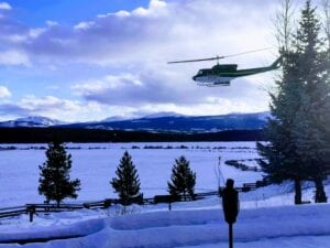 helicopter flies in front of snow covered field