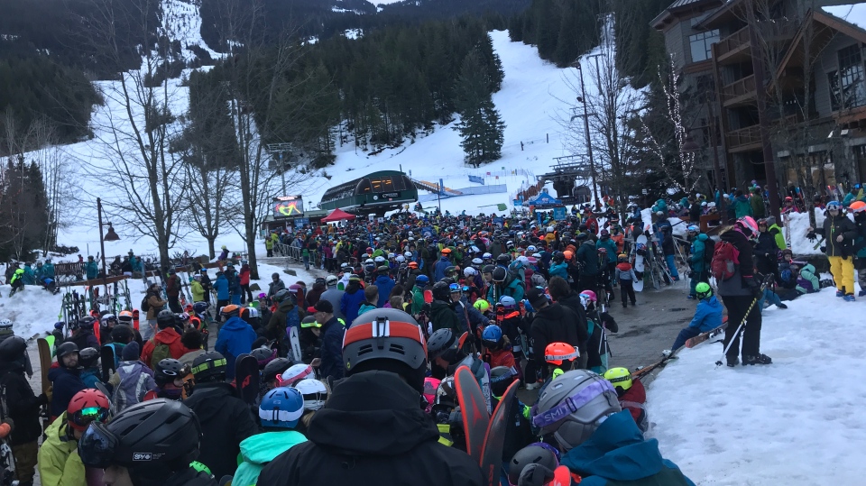 big crowd lining up at ski lift station in Whistler