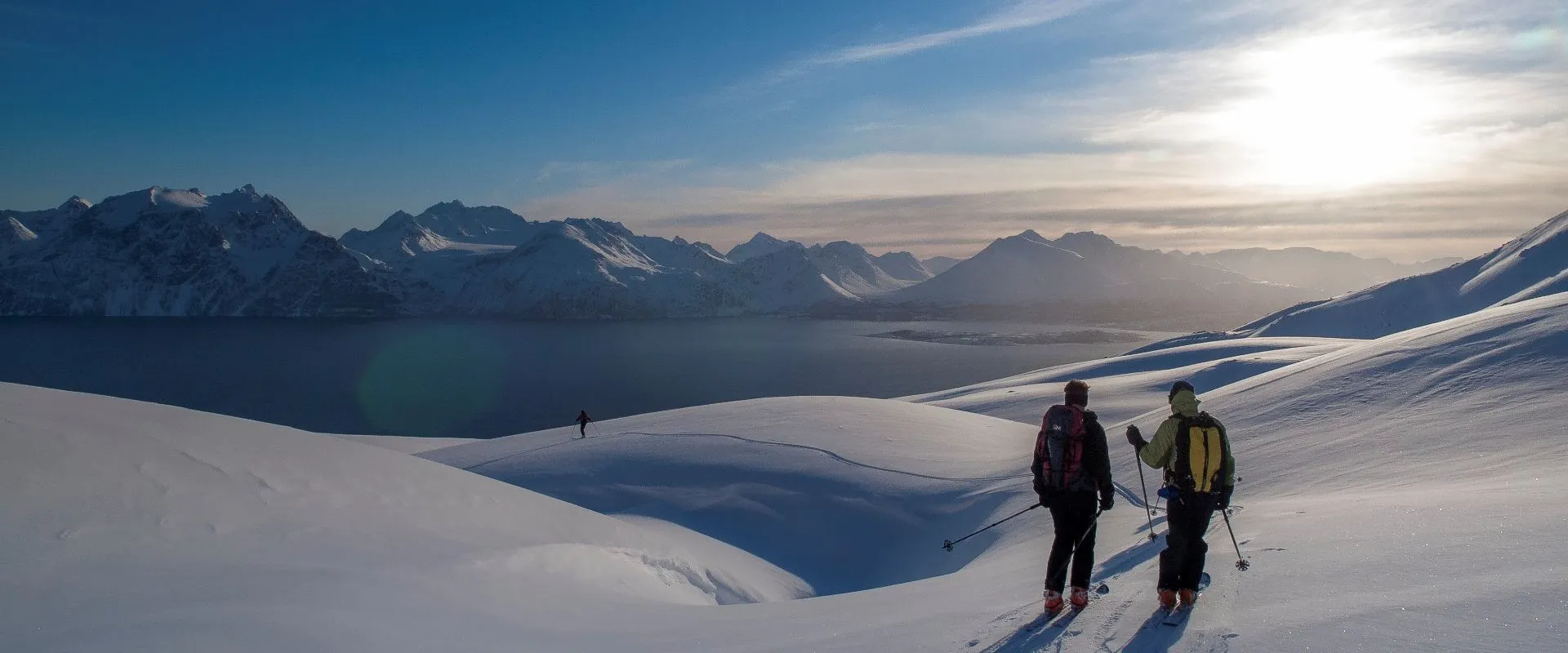 3 skiers at the bottom of the Nordmannvik descent in Lyngen Alps Norway